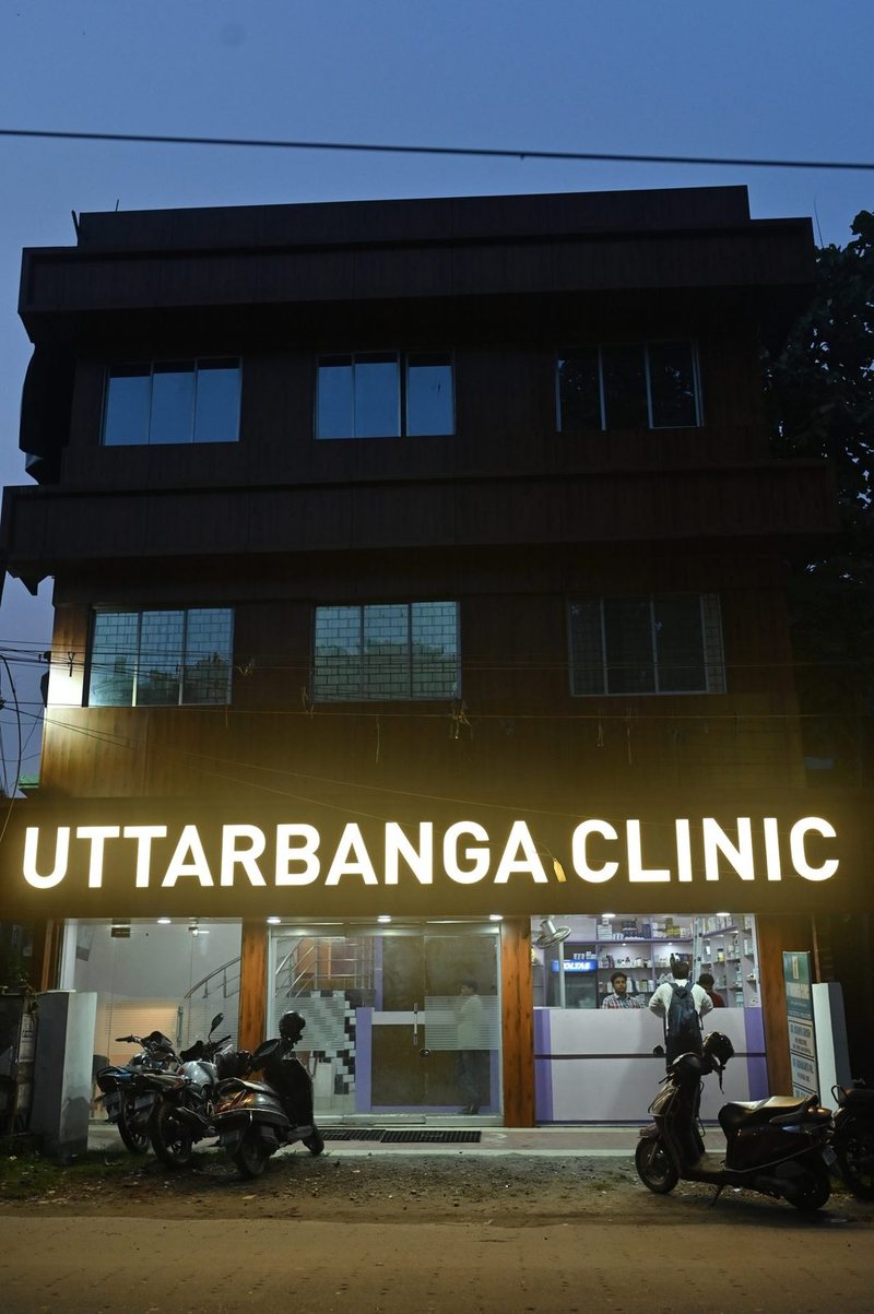 Uttarbanga Clinic building with illuminated signage after dark, Sunity Road, Cooch Behar