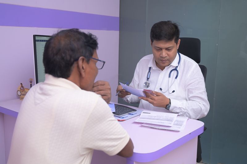 Dr Soumya Ghosh going through a patient's previous prescriptions and lab reports at Uttarbanga Clinic, Cooch Behar