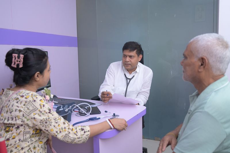 Dr Soumya Ghosh discussing thyroid test results with a patient and family member at Uttarbanga Clinic, Cooch Behar