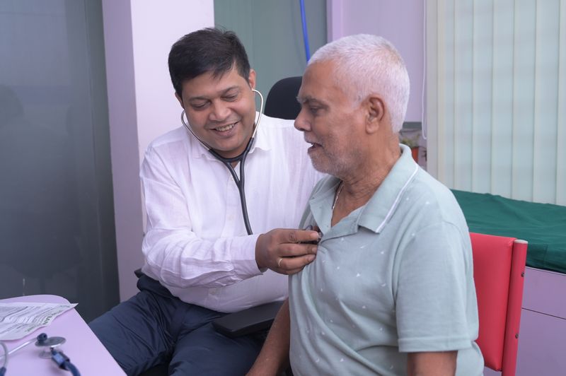 Dr Soumya Ghosh examining a patient with a stethoscope at Uttarbanga Clinic, Cooch Behar